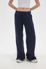 Pantalon deportivo de corte recto y tiro medio, color azul marino. Presenta una banda lateral blanca y aberturas ajustables con cordones en los tobillos. Cuenta con cintura elástica.