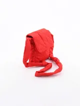 Mochila pequeña acolchada color rojo con patrón de rombos. Tiene solapa con cierre magnético y correa de hombro acolchada.