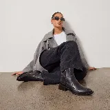 Botas de cuero negro con acabado desgastado, taco cuadrado de madera, punta cuadrada y cierre lateral interno.
