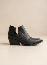 Botín de cuero vacuno color negro, con diseño de corte lateral y taco cuadrado de 5 cm. Presenta punta fina y suela de caucho antideslizante.