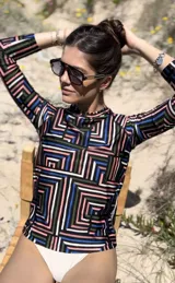 Remera de lycra con protección UV, de manga larga y cuello alto. Diseño con estampado geométrico abstracto en tonos negro, blanco, rosa, azul y verde.