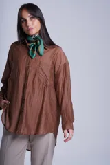 Camisa negra de tela traslúcida con cuello clásico, cierre frontal con botones y dos bolsillos de parche en el pecho.