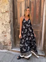 Vestido largo negro con estampado de cachemir en blanco y beige. Tiene breteles finos y corte amplio.