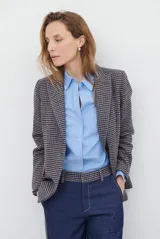 Camisa de corte recto confeccionada en tela Oxford, color azul claro. Presenta cuello clásico, cierre frontal con botones, mangas largas con puños abotonados y un bolsillo aplicado en el pecho.