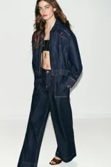 Jeans de tiro medio con corte wide leg y pernera ancha. Presenta bolsillos de plastrón en el delantero y cierre frontal con cremallera y botón.