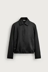 Cazadora regular fit de hombre confeccionada en tejido efecto ante de color negro, con cuello solapa, bolsillos de vivo en la cadera, bajo elástico y cierre frontal con cremallera.
