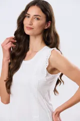 Musculosa de algodón color azul con detalles de broderie calado en los hombros, de cuello redondo y corte clásico.