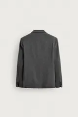 Blazer de corte relaxed fit color gris, confeccionado en tejido con lana. Cuenta con solapas de pico, manga larga con botones en los puños, bolsillos con solapa en la cadera y un bolsillo de vivo en el pecho. Presenta cierre frontal de botonadura cruzada con botones oscuros.