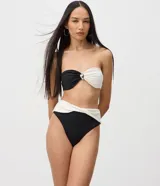 Bombacha de bikini tipo hot pant confeccionada en microfibra, con diseño bicolor en negro y blanco estilo color block. Presenta cintura alta con pretina cruzada.