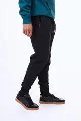 Pantalon de jogging de felpa en color gris melange, con cintura elástica ajustable mediante cordones, puños en los tobillos y paneles laterales en contraste de color negro en la parte inferior de las piernas.