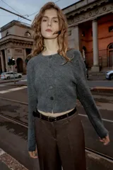 Pantalón de tiro alto con pernera recta, confeccionado en tejido de textura sutil. Cuenta con cierre frontal de cremallera, botón interior y gancho, bolsillos laterales y falsos bolsillos traseros de vivo. Incluye un cinturón fino a juego con hebilla metálica.