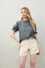 Short de algodón color beige, con diseño clásico de cinco bolsillos, tiro medio y terminación recta.