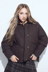 Campera acolchada de color negro con diseño capitoneado, cierre frontal con botones y cuello clásico.