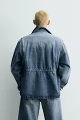Parka de denim de algodón con efecto lavado, de color azul medio. Presenta cuello solapa, manga larga con puño abotonado, cierre frontal de botonadura oculta y cintura ajustable con cordón interior. Posee cuatro bolsillos utility de plastrón con solapa: dos en el pecho y dos en la cadera.