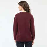 Sweater de punto grueso color bordó, con cuello redondo y mangas largas con puños acanalados.