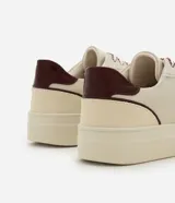 Championes casuales Satinato de diseño urbano, confeccionados en poliuretano con recortes superpuestos y costuras visibles. Presentan puntera redondeada con microperforaciones, suela alta de goma, refuerzo trasero en color contrastante y cordones con diseño diferenciado.