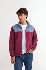 Campera de polar con corderito, color bordó en la parte inferior y celeste en la parte superior. Tiene cuello alto, cierre frontal completo y bolsillos laterales.
