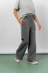 Pantalón blanco de silueta amplia y caída fluida, con cintura alta elastizada y lazo regulable con terminaciones metálicas.