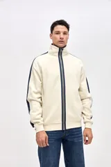 Campera de felpa con friza, de corte relajado, color negro con detalles en bordó. Presenta cuello alto, cierre frontal metálico, bolsillos laterales y cintas decorativas a contratono en las mangas.