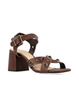 Sandalias de taco cuadrado alto y color marrón chocolate, con tiras anchas en el empeine decoradas con tachas metálicas y tira ajustable con hebilla en el tobillo.