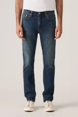 Jeans de corte slim fit en denim azul con lavado clásico, diseño de cinco bolsillos y cierre frontal con botones.