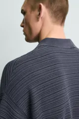 Polo de punto de algodón con textura acanalada, color verde militar, efecto lavado, cuello solapa, cierre frontal con botones y mangas cortas holgadas.