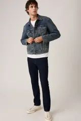 Jean de corte slim fit en color azul oscuro, con diseño clásico de cinco bolsillos, cierre de cremallera y botón metálico.