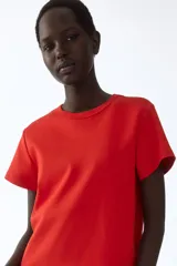 Remera roja de manga corta confeccionada en punto de algodón tupido, con cuello redondo ribeteado y acanalado.
