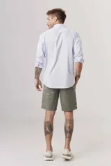 Camisa celeste a rayas verticales blancas, de corte clásico, manga larga y cuello abotonado.