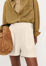 Short de corte holgado color lila, con cintura elástica y dos bolsillos frontales amplios.