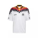 Camiseta de fútbol Adidas titular de Alemania de 1994, de manga corta, color blanco con diseño gráfico geométrico en el pecho y cuello en los colores negro, rojo y amarillo.