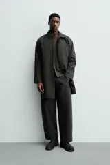 Gabardina impermeable de corte regular fit en color verde militar, con cuello solapa, manga larga con puño ajustable con botones a presión y bolsillos de vivo en la cadera. Cierre frontal con cremallera oculta por solapa con botones a presión.