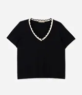 Blusa de viscolycra color beige con escote en V y cuello doble en tono negro con borde de ondas, de mangas cortas y corte amplio.
