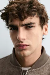 Cazadora bomber marrón con interior efecto pelo, cuello y puños de rib elástico, bolsillos de vivo en cadera, bolsillo interior y cierre frontal con cremallera.