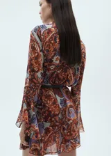 Vestido corto de tejido ligero con estampado paisley en tonos naranja, violeta y crema. Presenta cuello redondo con lazo, mangas largas con volantes y diseño evasé. Incluye forro interior y cinturón desmontable de cuero sintético.