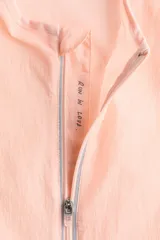 Campera de correr liviana color salmón, de corte estándar con cuello elevado, cierre frontal y tecnología DryMove para absorber el sudor.