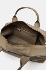 Bolso alargado tipo bowling color verde oliva, confeccionado en cuero con doble asa de mano y asa bandolera extraíble. Incluye bolsillo interior con cremallera y cierre principal con cremallera.