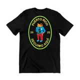 Remera negra de algodón con estampa gráfica en la espalda que presenta un sapo antropomórfico con ropa urbana y el texto Puerto Rico Seguimo Aquí.