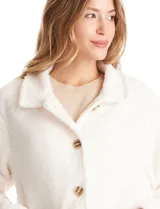 Sobrecamisa de tejido sherpa color blanco, con cuello solapa, cierre frontal con botones y bolsillos delanteros.