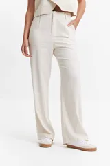 Pantalón de vestir color crema, de tiro medio, corte recto y pierna ancha.