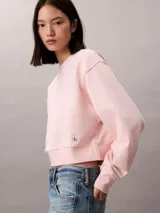 Buzo cropped de cuello redondo, confeccionado en algodón, con puños y dobladillo en punto canalé. Presenta un diseño minimalista con detalle de costura en V en el cuello.