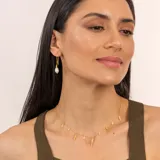 Collar dorado con cadena fina y dijes colgantes de perlas barrocas y piezas irregulares con textura.