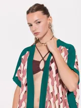 Poncho verde esmeralda con paneles estampados en tonos rosa y beige, cuello en V y mangas cortas.