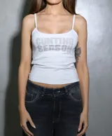 Musculosa blanca con tirantes finos, escote redondo y estampado frontal con pedrería brillante que forma el texto "CUNTING SEASON".