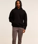 Pantalón skinny negro de sarga con elastano, estilo social, con cierre de botón y cremallera, y cintura con trabillas.