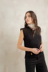 Chaleco tejido en lana merino, de cuello redondo y corte recto, con terminaciones acanaladas en cuello, sisas y ruedo.