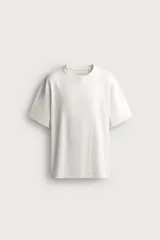 Camiseta de corte relajado confeccionada en tejido de algodón, con cuello redondo acabado en rib y manga corta.
