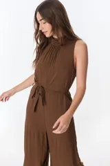 Mono marrón sin mangas, con cuello alto fruncido y lazo en la cintura.