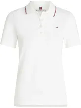 Chomba blanca de manga corta con corte slim, confeccionada en piqué de algodón y elastano. Presenta cuello con ribete tricolor (rojo, blanco y azul marino) y cartera de dos botones. Posee el logo de Tommy Hilfiger bordado en el pecho.