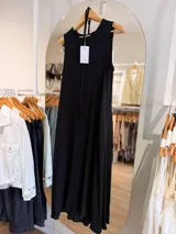 Vestido largo negro sin mangas, confeccionado en tela texturada con relieve, de corte fluido y diseño versátil.